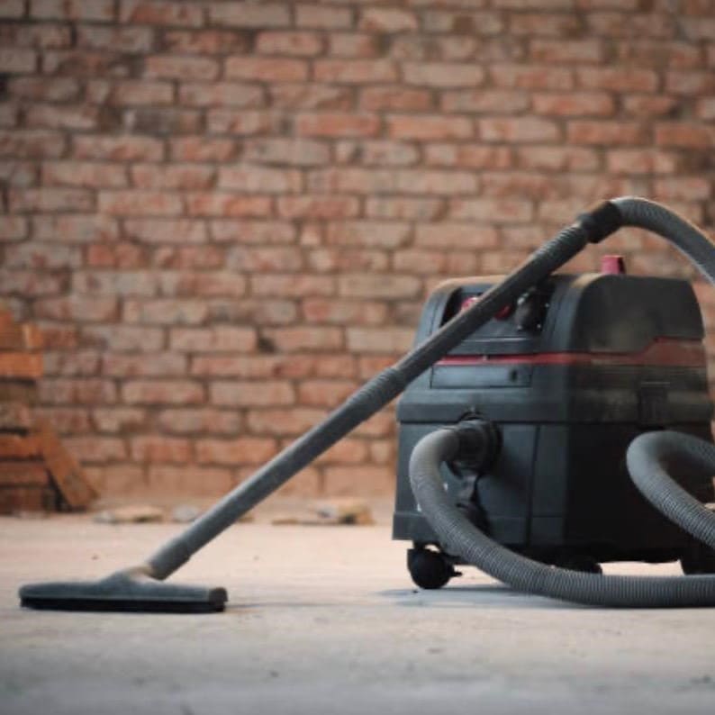 Bauendreinigung und Baustellenreinigung: Einsatz eines leistungsstarken Industriesaugers zur Entfernung von Baustaub nach Renovierungsarbeiten.